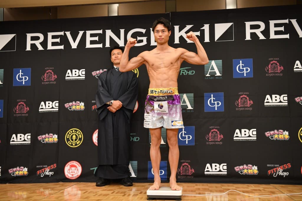 K-1 REVENGEの計量会で、両腕を上げてポーズをとるReBORN経堂所属・池田幸司選手