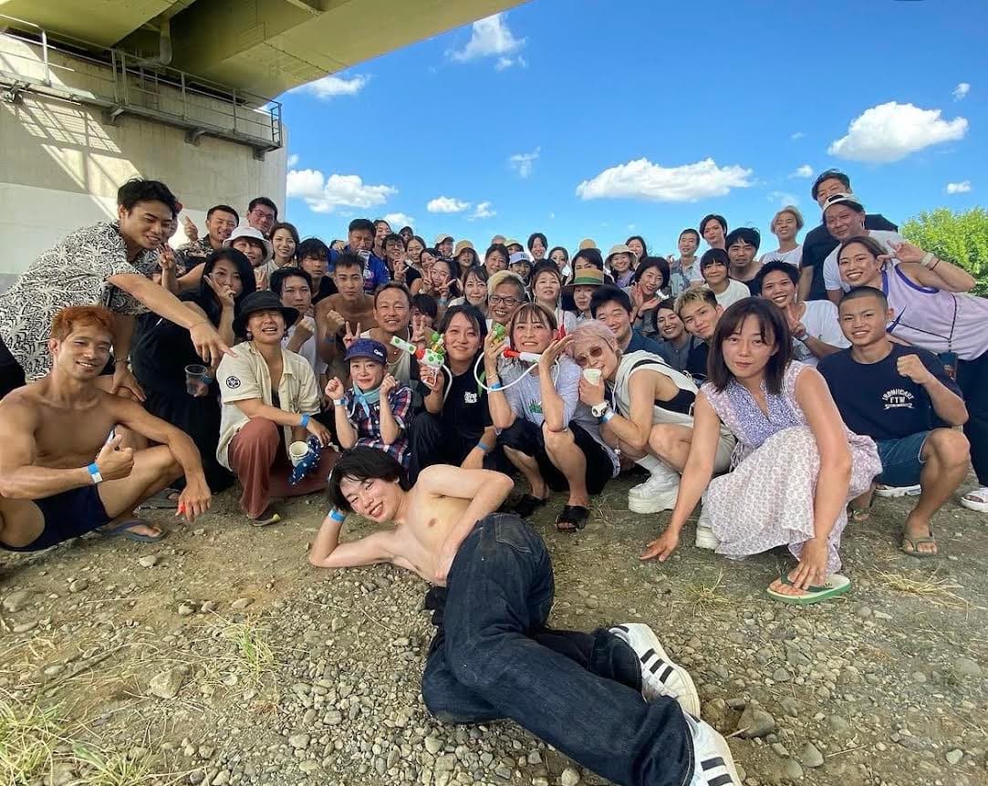 橋の下で大勢の会員がBBQを楽しむ集合写真